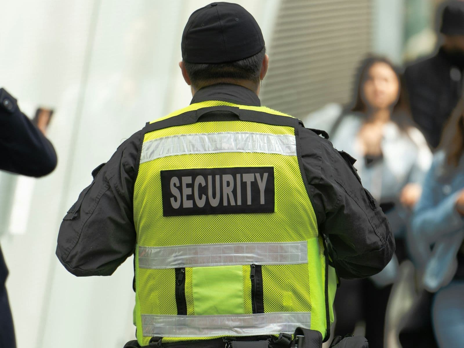 A licensed security guard in a high-visibility vest on duty